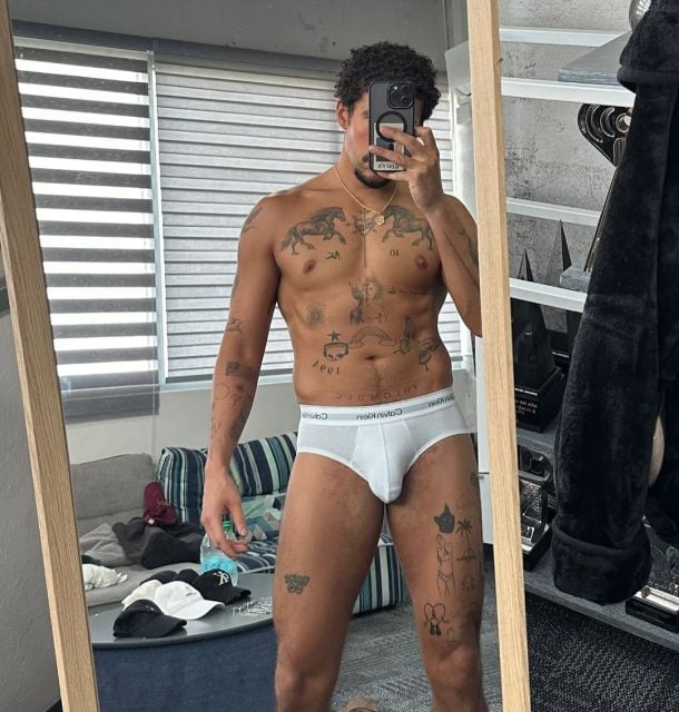 Bad Bunny takes a mirror selfie in white Calvin Klein briefs, displaying his muscular physique and tattoos.