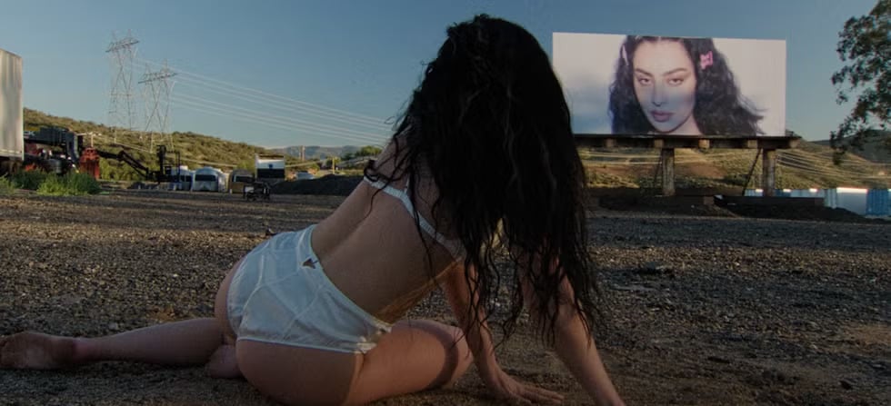 Charli XCX seeing a billboard of herself in the music video for 'party 4u.' Photo: Atlantic Records/Charli XCX