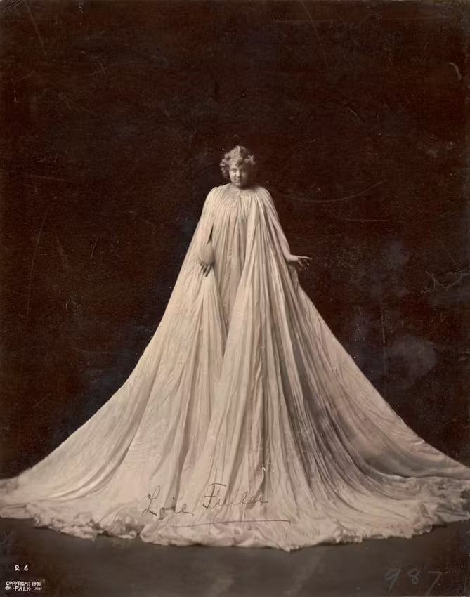 Loie Fuller in her gown equipped with concealed rods to allow her to wield a pair of enormous wings, 1901