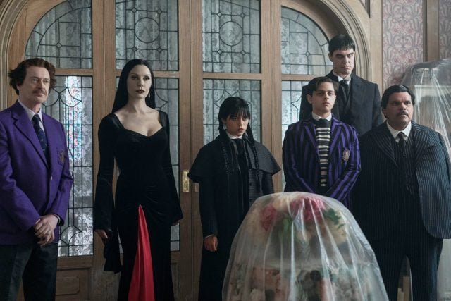 Wednesday. (L to R) Steve Buscemi as Barry Dort, Catherine Zeta-Jones as Morticia Addams, Jenna Ortega as Wednesday Addams, Isaac Ordonez as Pugsley Addams, Joonas Suotamo as Lurch, Luis Guzmán as Gomez Addams in episode 201 of Wednesday. Cr. Jonathan Hession/Netflix © 2025