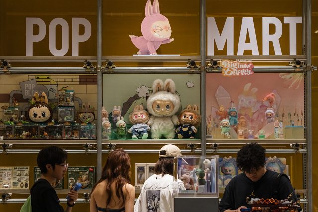 Customers browse a POP MART display filled with Labubu characters and collectible figures from The Monsters series on June 16, 2025 in Chongqing, China. The Labubu IP has surged in popularity among China's Gen Z, with limited-edition drops, co-branded products, and immersive storefront experiences turning designer toys into a mainstream cultural phenomenon.