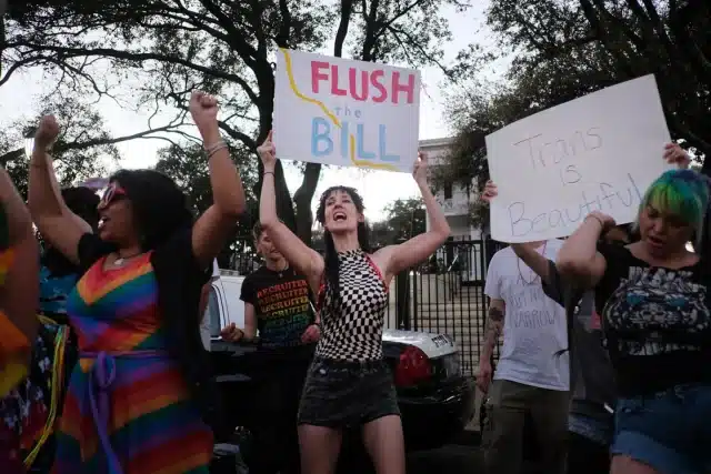 Texas Governor Greg Abbott signs bill restricting trans people from public bathrooms, prisons, and shelters, sparking national criticism. 