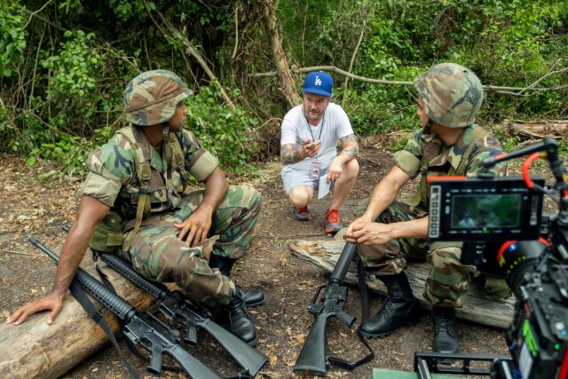BOOTS. (L to R) Rico Paris as Santos, Director Silas Howard (104, 105), and Johnathan Nieves as Ochoa behind the scenes of Episode 104 of Boots. Cr. Patti Perret/Netflix © 2024
