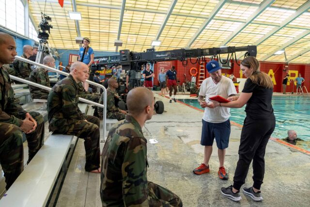 BOOTS. (L to R) Rico Paris as Santos, Angus O’Brien as Hicks, Liam Oh as Ray McAffey, and Director Silas Howard (104, 105) behind the scenes of Episode 104 of Boots. Cr. Patti Perret/Netflix © 2024