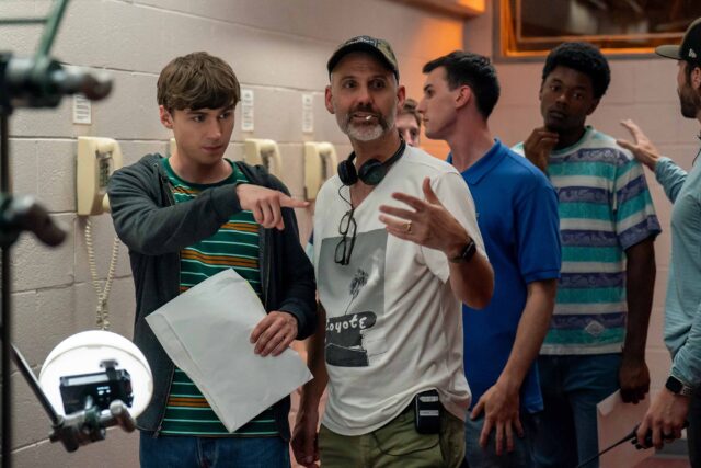 BOOTS. (L to R) Miles Heizer as Cameron Cope and Director Peter Hoar (101) behind the scenes of Episode 101 of Boots. Cr. Alfonso "Pompo" Bresciani/Netflix © 2023