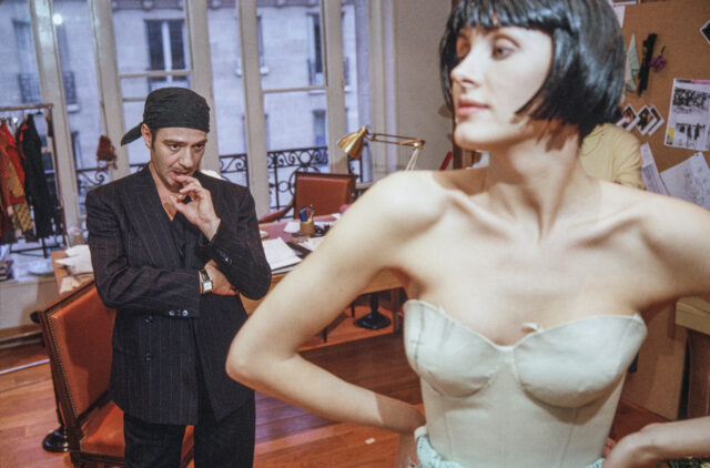 PARIS, FRANCE - 2005. British fashion designer John Galliano pictured working with a fashion model and assistants during a fitting session in the original former wooden panelled atelier of the legendary French fashion designer Christian Dior at the headquarters of the luxury fashion brand located on the Avenue Montaigne, Paris. 