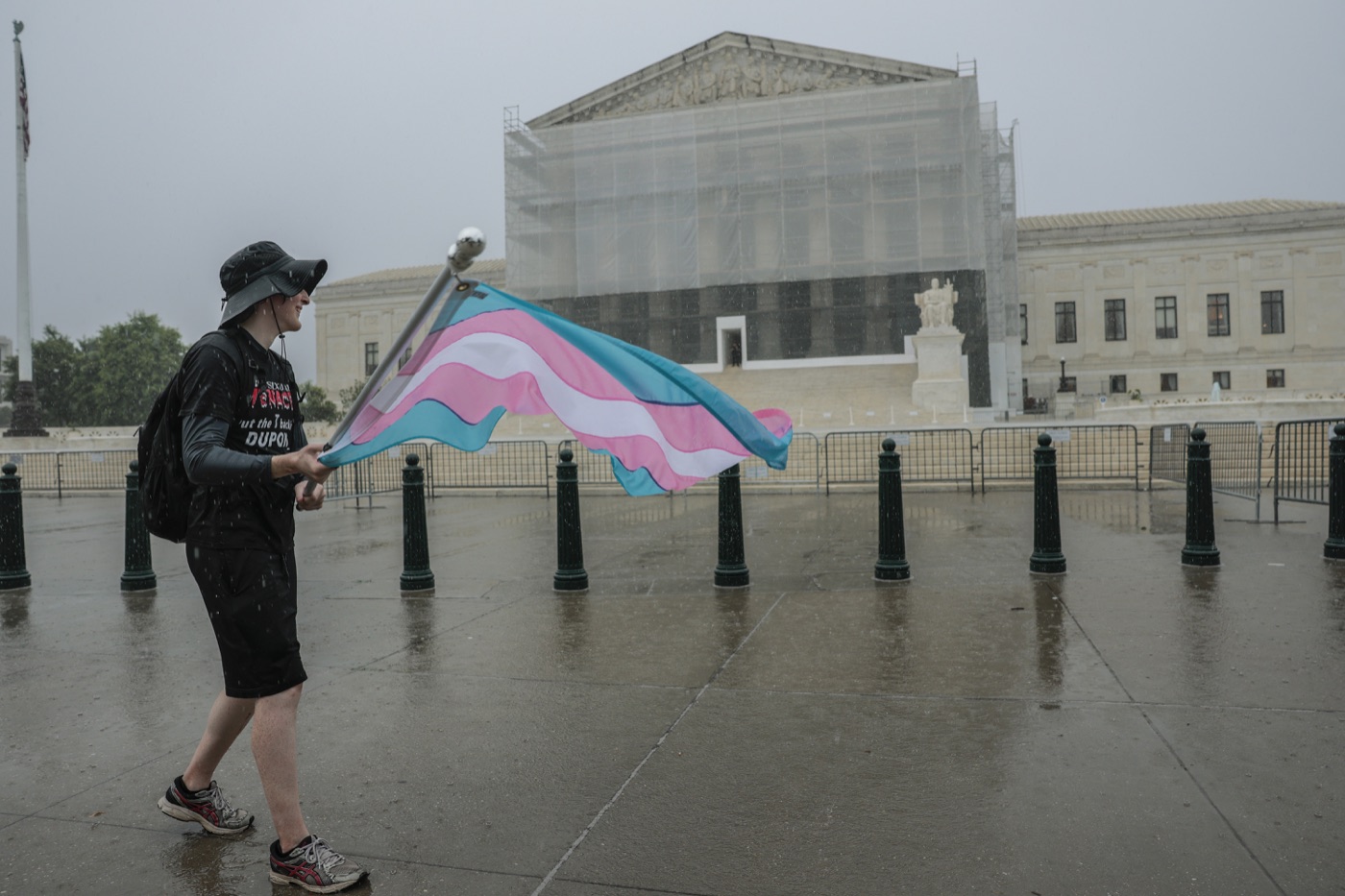 A protester waves a transgender pride flag outside the U.S. Supreme Court in June 2025.